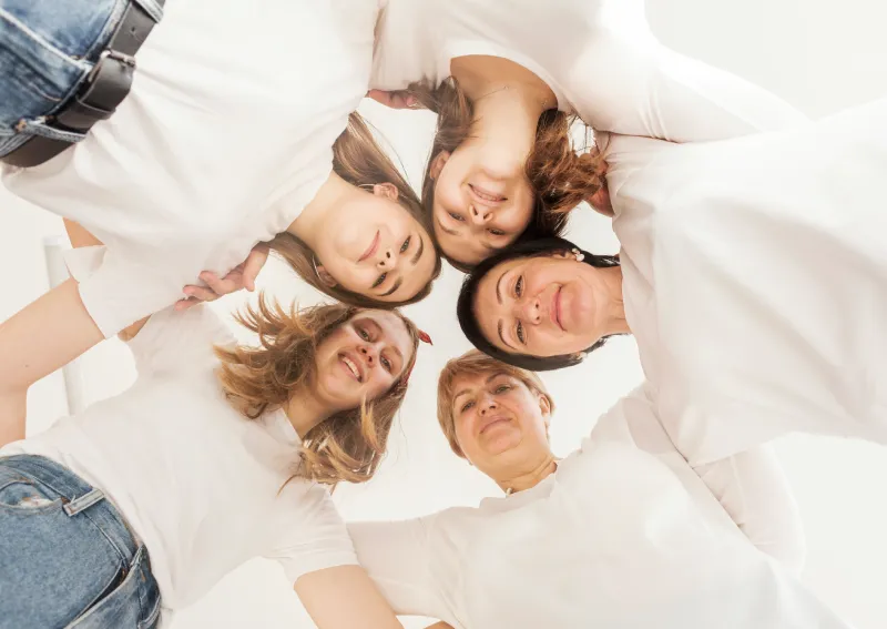 Frauen stehen im Kreis und schauen nach unten